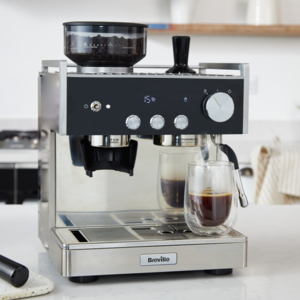 espressor barista signature cu pahar de cafea pe masa