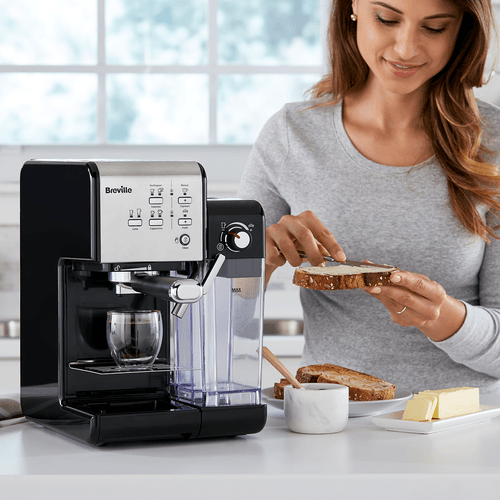femeie pregatind sandwich langa espressor breville prima latte 2 negru